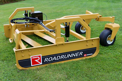 Yellow Roadrunner Series dual-blade grader with hydraulic cylinders and dual wheels on grass