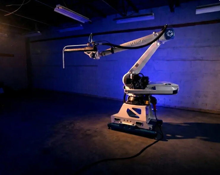 Industrial robotic arm with articulated joints displayed in blue-lit exhibition space