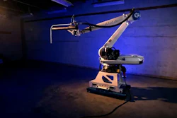 Industrial robotic arm with articulated joints displayed in blue-lit exhibition space