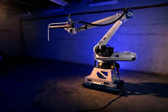 Industrial robotic arm with articulated joints displayed in blue-lit exhibition space