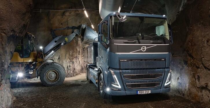 Volvo truck and forklift operating in underground mine tunnel with LED lighting