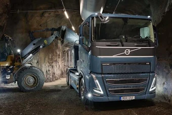 Volvo truck and forklift operating in underground mine tunnel with LED lighting