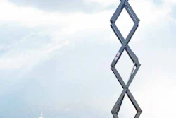 Yellow XCMG XG2632AC scissor lift platform fully extended against city skyline backdrop